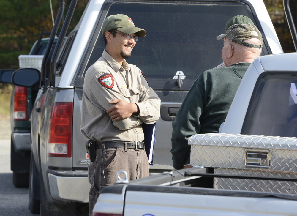 Kyle Ravana, the Department of Inland Fisheries and Wildlife deer biologist, talks with hunter Floyd Whitmore of Norridgewock in Solon in 2013. Ravana said the official numbers aren’t in from this year’s deer hunting season, but he’s hearing it was a good one.