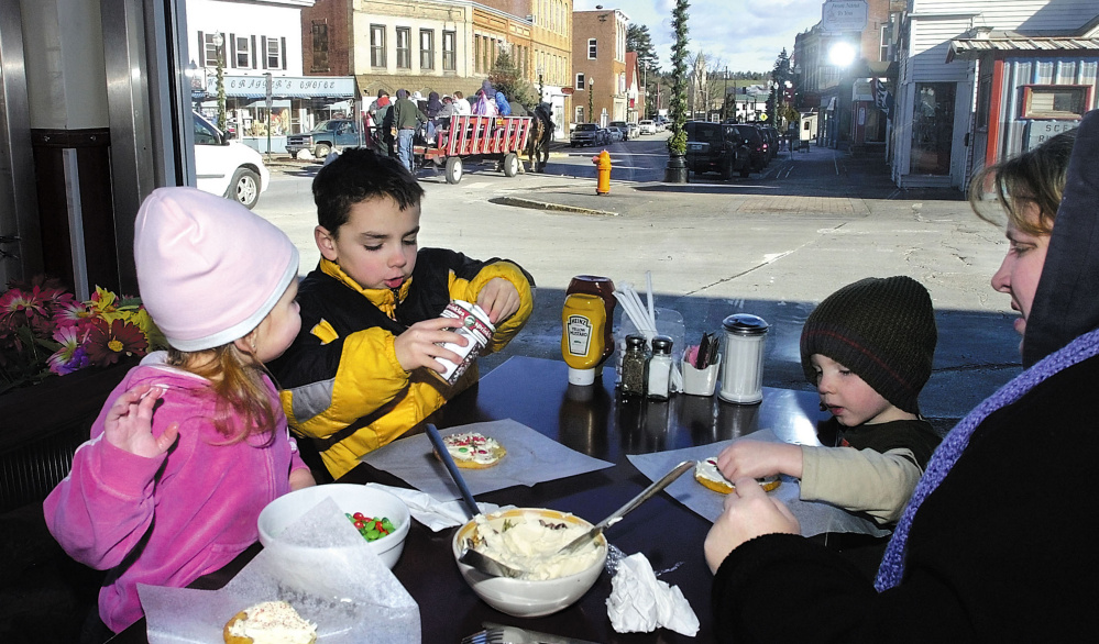 Part of the annual Holiday Stroll in Skowhegan last year was cookie decorating at the Empire Grill. From left to right is Isabella Mullen, 2, her brothers Isaiah Cole, 6, Noah Cole, 2, and their mother Heidy Mullen. This year’s two-day event begins Friday.
