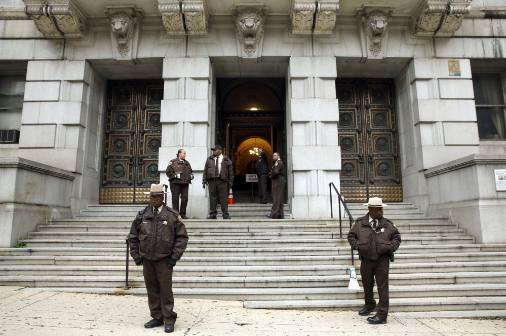 Members of the Baltimore City Sheriff’s Office stand outside Clarence M. Mitchell Jr. Courthouse, Monday in Baltimore, after the arrival of William Porter, one of six Baltimore city police officers charged in connection to the death of Freddie Gray.