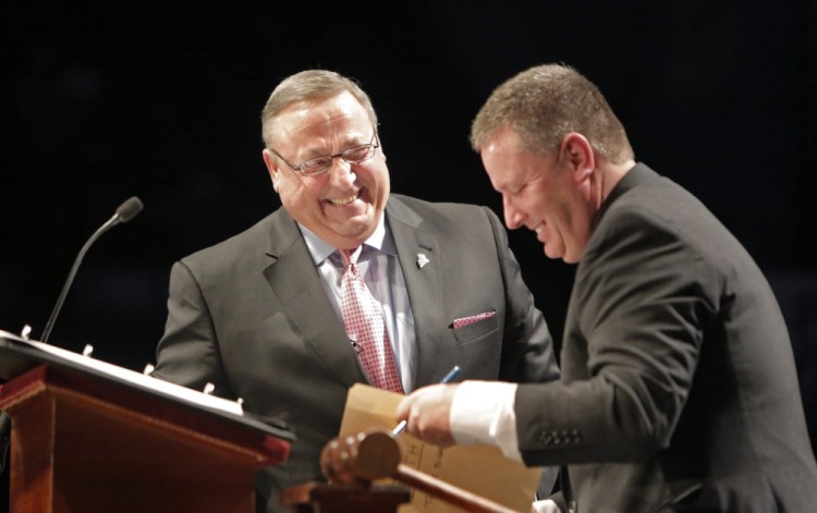 Gov. Paul LePage laughs with Senate President Mike Thibodeau after signing paperwork after LePage took the oath of office at his inauguration at the Augusta Civic Center on Jan. 7, 2015. If LePage lands a spot in a Trump administration, Thibodeau would fill out his unexpired term.
