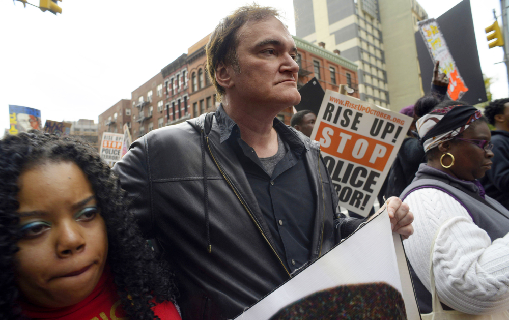 Director Quentin Tarantino, center, says he’s been bullied by police groups who call for boycotting his next film.
