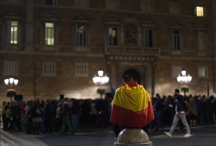 A man wraps himself in a Spanish flag during a demonstration calling for the “unity of Spain” in Barcelona on Thursday.
