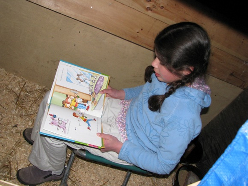 Lucia, 10, reads to her pigs.