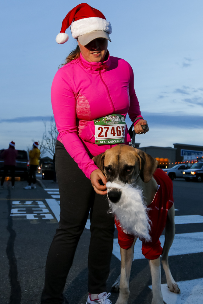 SOUTH PORTLAND, ME - NOVEMBER 22: Tina Chadbourne, of Bucksport, adjusts a fake beard on Wilson -- a 7-month-old Great Dane -- minutes before the running of the annual Santa Hustle Half Marathon and 5K on Sunday at the Maine Mall. (Photo by Ben McCanna/Staff Photographer)