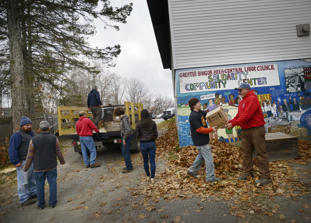 Solidarity Harvest volunteers carry apples for Thanksgiving baskets into Solidarity Center in Brewer on Thursday. The nonprofit bought 5,900 pounds of produce from 30 Maine farms.