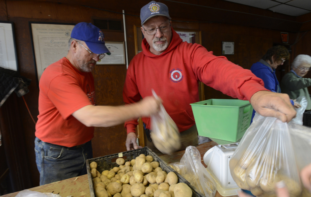 Rory Devine of Herman and Kelly Jordan of Ellsworth, both with Local 2327 IBEW, pack potatoes for Thanksgiving baskets on Thursday for Food AND Medicine, a Brewer nonprofit.
Shawn Patrick Ouellette/Staff Photographer