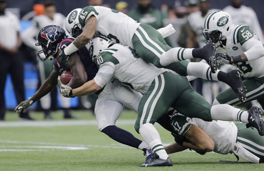 Houston receiver Keith Mumphery is stopped by Rontez Miles, top, and Tommy Bohanon of the Jets during Sunday’s game in Houston. The Texans won, 24-17.