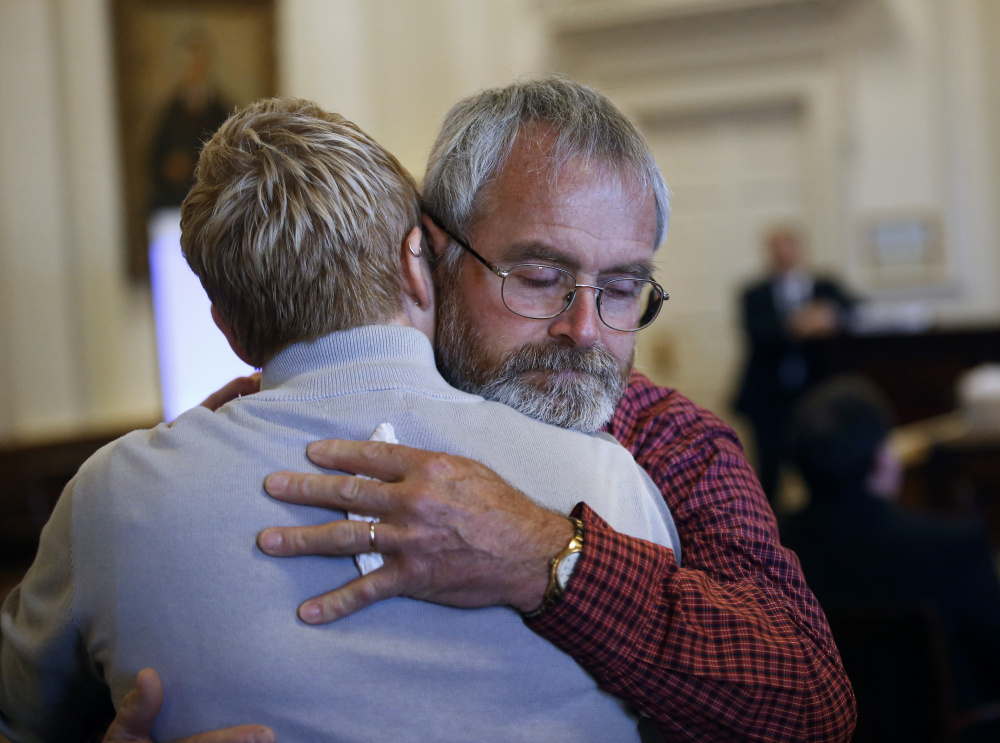 Jeffrey Boudreau, the husband of Wendy Boudreau, embraces one of his daughters after they testified Monday at the sentencing hearing in Alfred for Connor MacCalister, who pleaded guilty to murdering Wendy Boudreau.