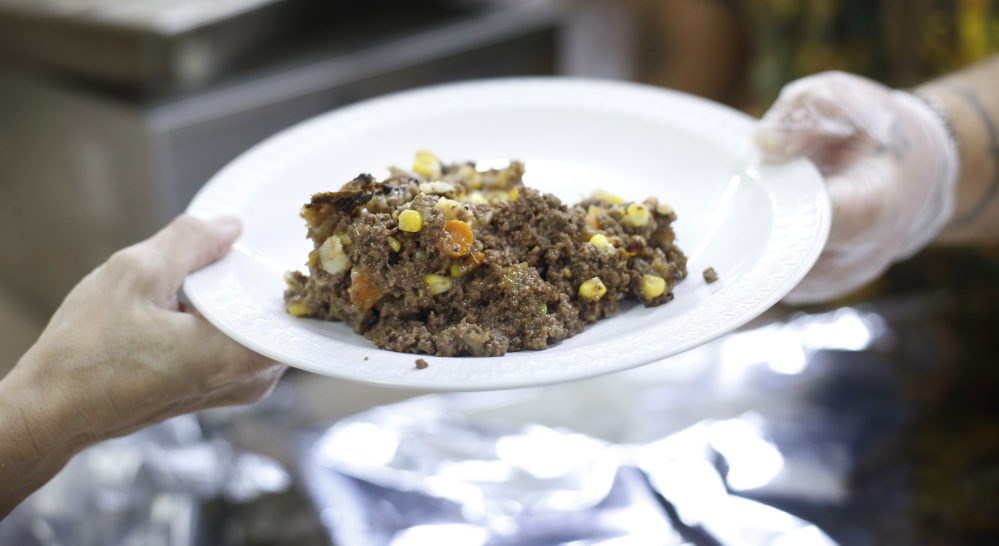 A plate of shepherd’s pie made with venison and moose meat is served at a church dinner in Portland. State officials laud hunters for donating game meat to food banks and other charities.