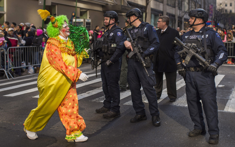 A clown marches past heavily armed police officers during the Thanksgiving Day parade in New York. “It’s a little scary, but at least it’s keeping us safe,” said Kim Miller of Boston.
