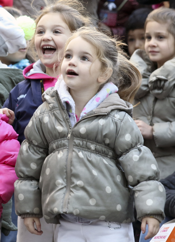 Children react as Santa Claus passes on a large float to cap off Thursday’s parade.