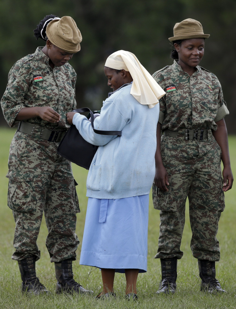 Below, a nun has her bag checked by army soldiers as she arrives to attend a meeting held by the pope.