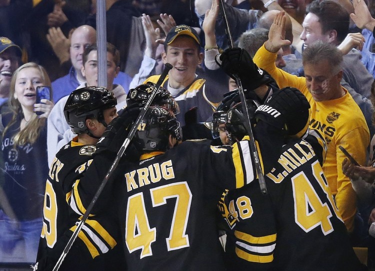The Bruins’ Torey Krug (47), Colin Miller (48) and teammates celebrate the go-ahead goal by David Krejci, back right, late in the third period of Friday’s afternoon game against the New York Rangers in Boston. The Bruins won, 4-3.