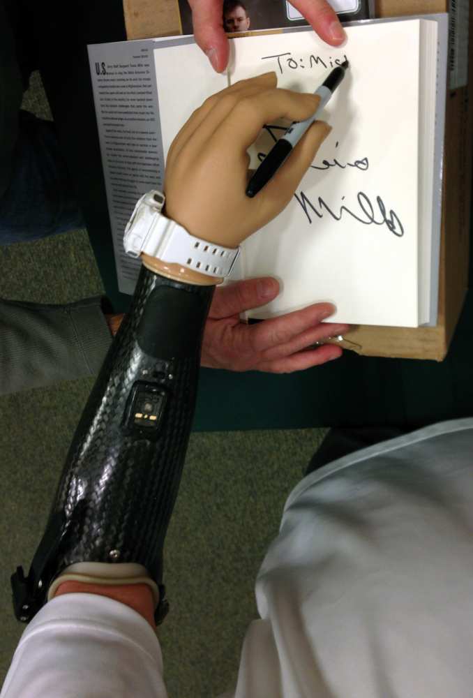 Travis Mills autographs a copy of his book “Tough As They Come” on Tuesday at the Barnes and Noble store in Augusta.