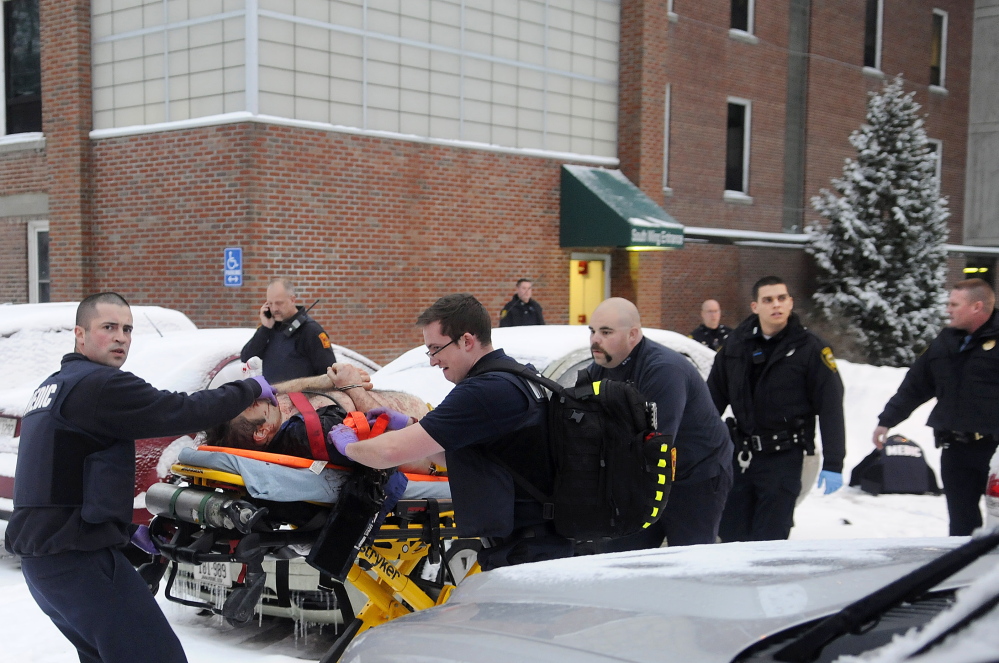 Firefighters and police escort a man, later identified as Jason Begin, who was shot by an Augusta police officer on Jan. 12 following a confrontation at an office at the former MaineGeneral Medical Center in Augusta.