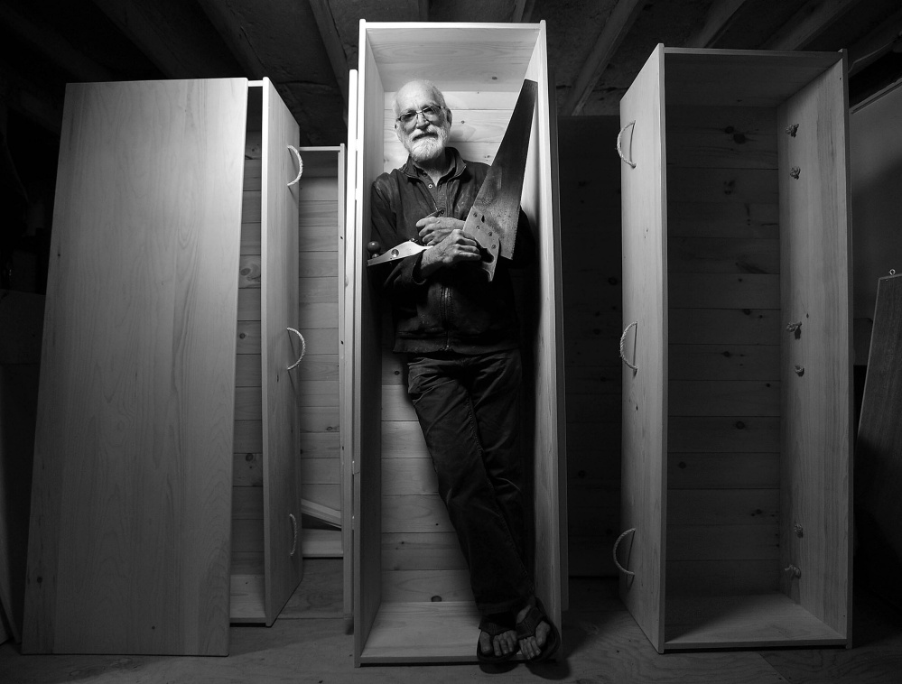 Chuck Lakin stands inside one of his hand-made coffins in 2013 in his workshop in the basement of his Waterville residence.
