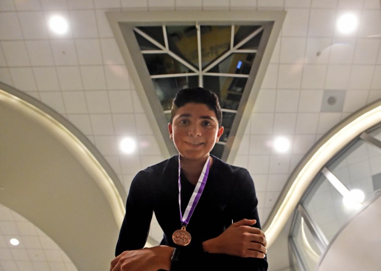 Gabe Ferris, 14, displays his medal from a national writing contest while at Waterville Senior High School.