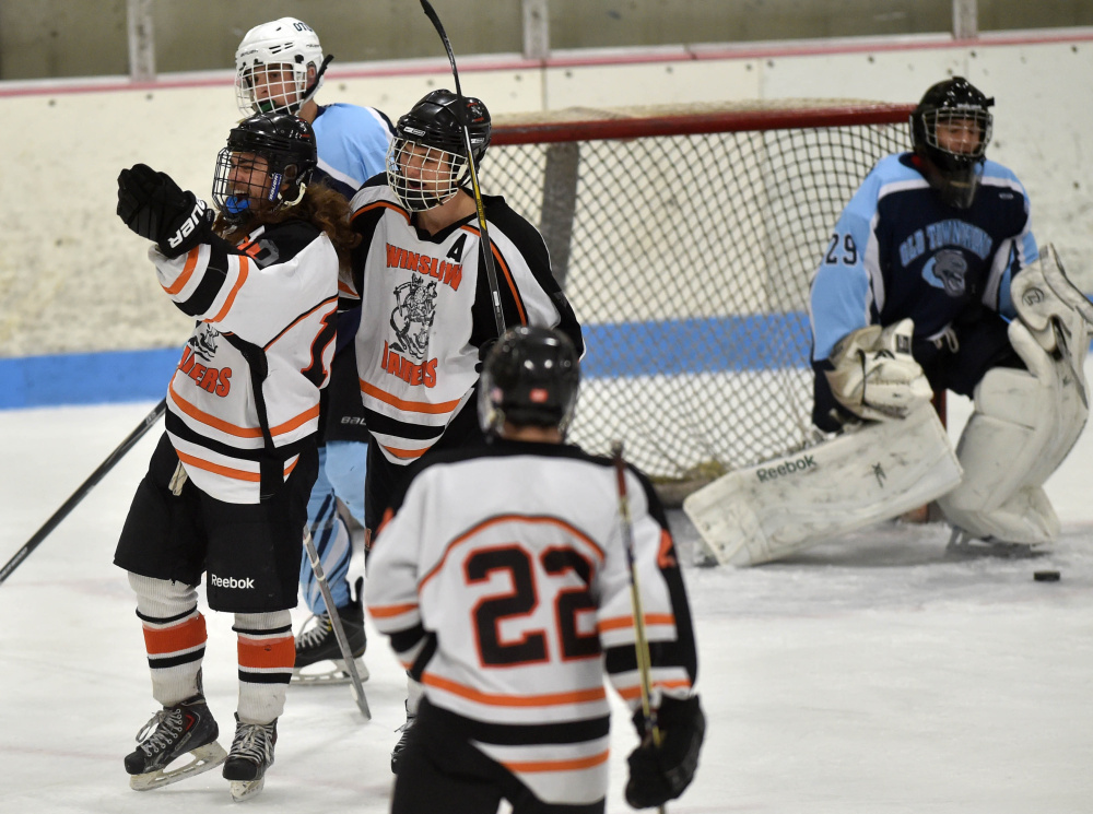 Winslow High School’s Jacob Grenier, left, celebrates his first period goal with linemate Jimmy Fowler (7) during a Class B North game against Old Town/Orono on Saturday night at Sukee Arena.