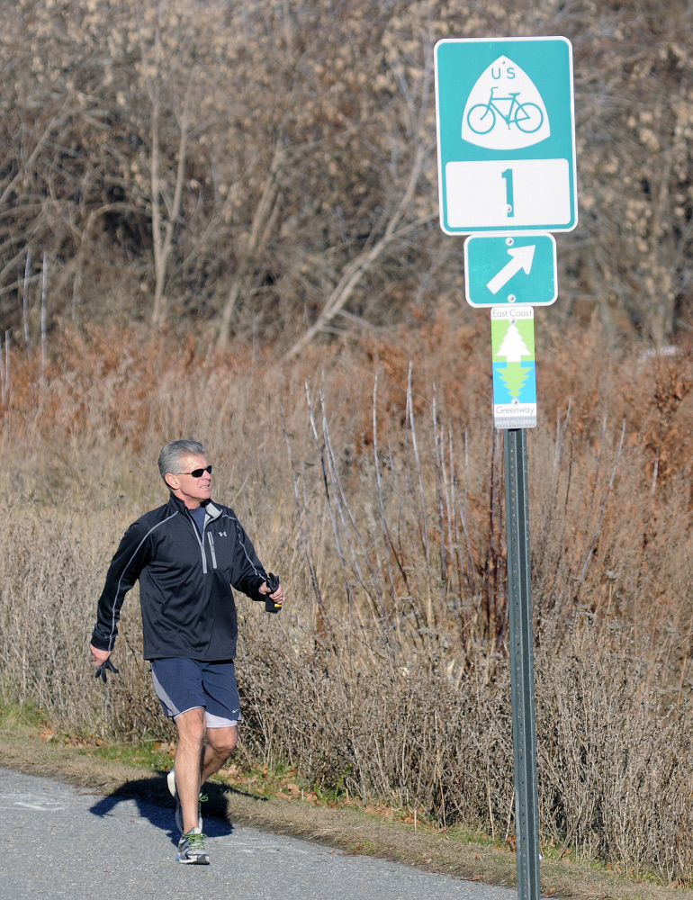 Jim Pietkiewicz, of Topsham, jogs Monday on the Kennebec River Rail Trail near Hallowell. Signs marking the East Coast Greenway bike trail have gone up in Augusta and Hallowell recently, as the trail continues to try to expand its reach.