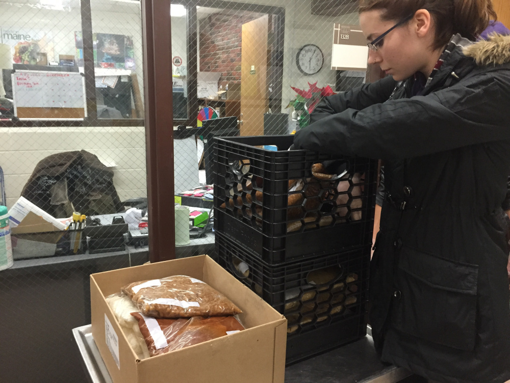 Catherine Dufault sorts through crates of vegetables, rice and Beef Stroganoff recovered from the Aramark dining service at UMF, as part of the UMF chapter of the Food Recovery Network she established to reduce food waste and help the hungry in Franklin County.