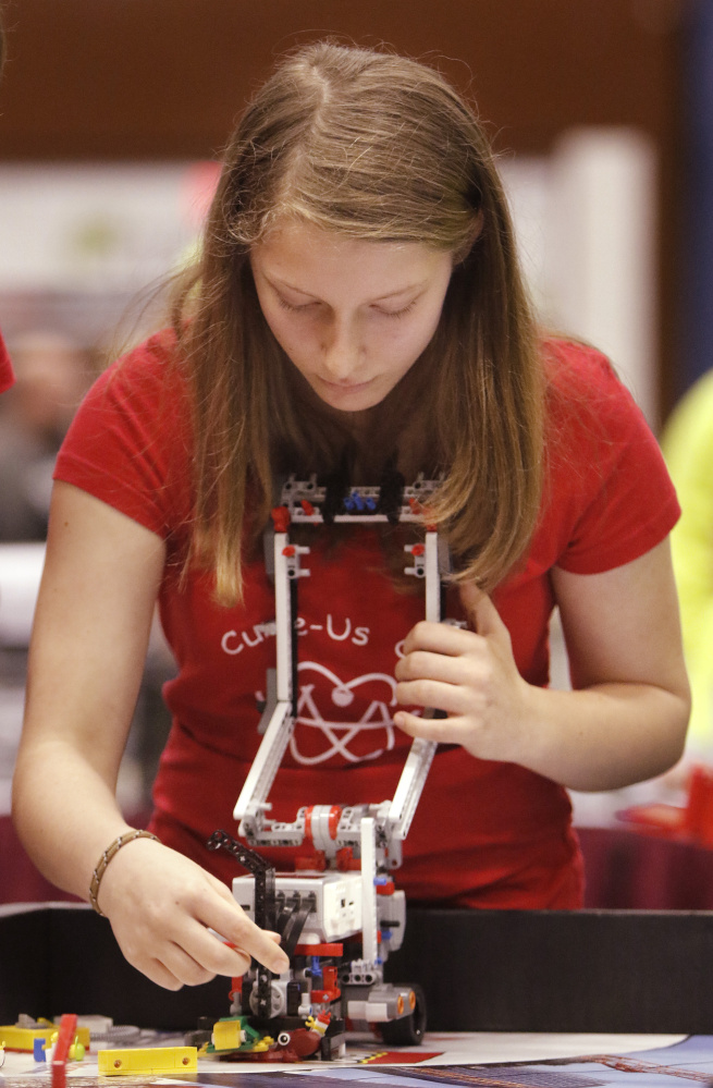 Skye Howard, an eighth-grader at Peninsula School in Gouldsboro, adjusts her team’s robot Saturday while competing in the Maine FIRST LEGO League State Championship at the Augusta Civic Center. Sixty teams from around the state competed in the championship.