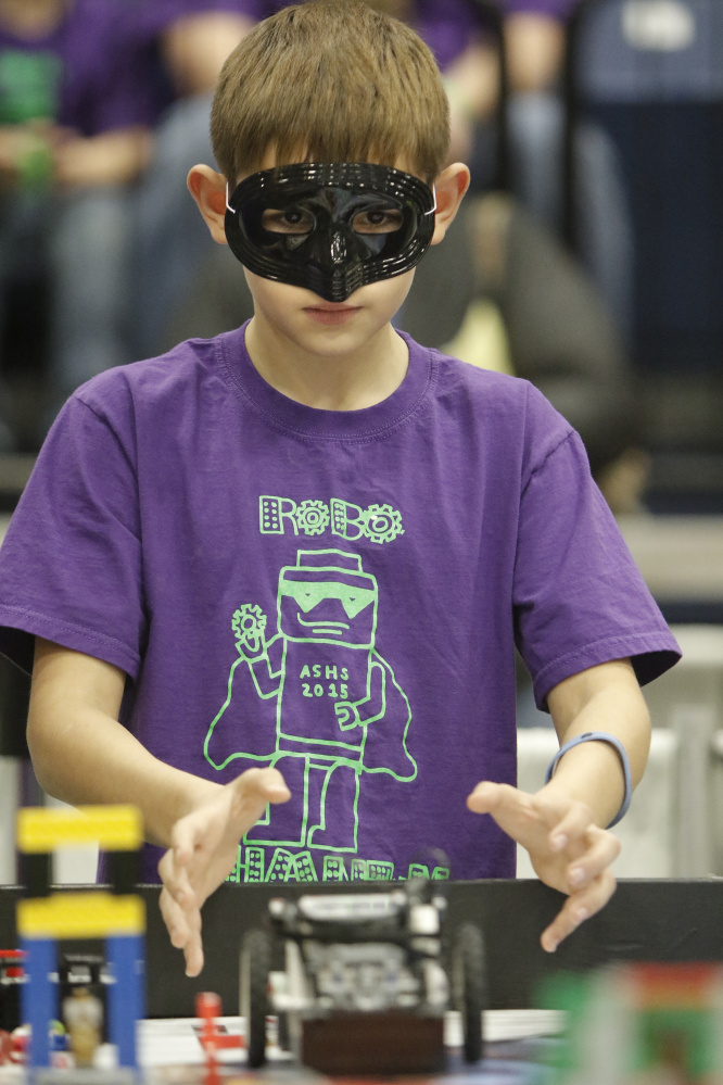 J.T. Trenholm, an fifth-grader at Albert S. Hall School in Waterville, lets go of his team’s robot Saturday while competing in the Maine FIRST LEGO League State Championship at the Augusta Civic Center. Trenholm is wearing a mask as part of the costume of his team, named the Robo Phantoms. Sixty teams from around the state competed in the championship.