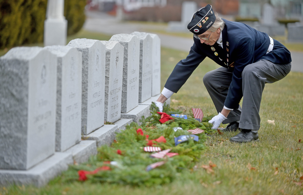 Paul Pontbriand, president of Waterville VFW Post 1285’s men’s auxiliary, places a wreath on a military veteran’s grave Saturday at St. Francis Cemetery on Grove Street in Waterville.