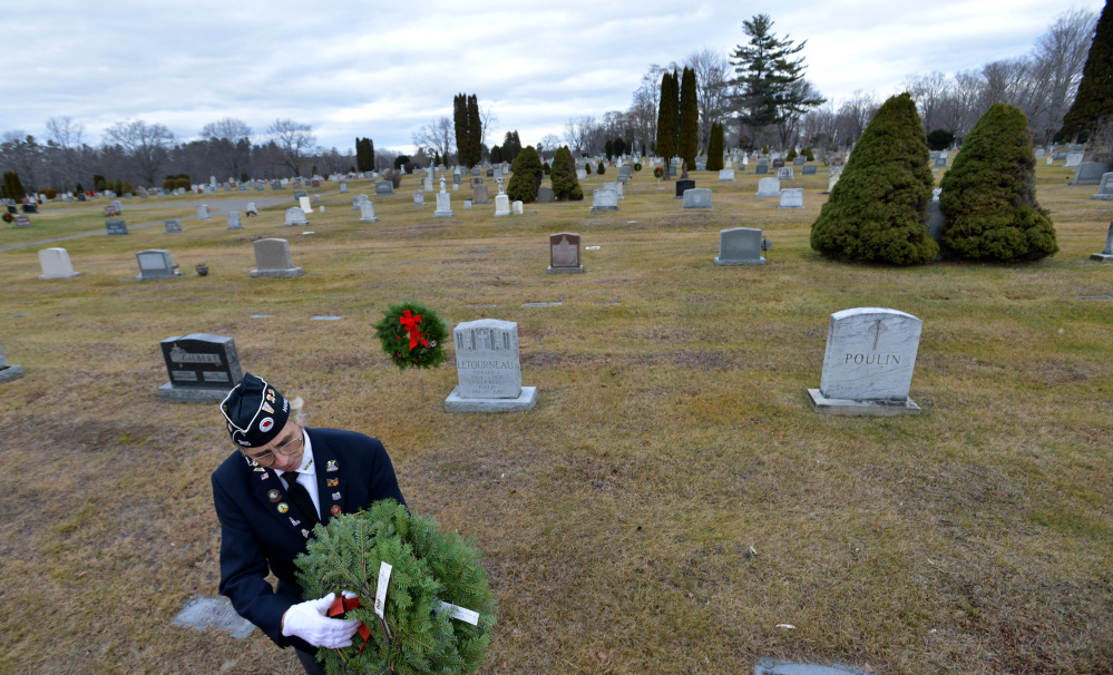 Paul Pontbriand, president of Waterville VFW Post 1285’s men’s auxiliary, holds a wreath destined for a veteran’s grave Saturday at St. Francis Cemetery on Grove Street in Waterville.