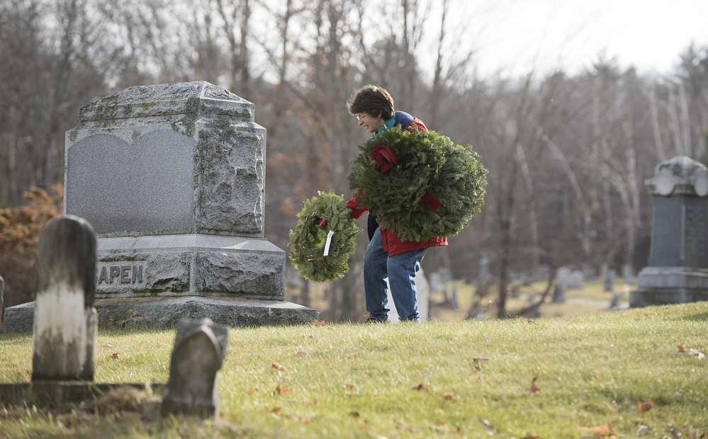 Annie Cough, of Gardiner, lays a wreath Saturday on a veteran’s grave in Oak Grove Cemetery in Gardiner. Organizer Steve Hanley, of American Legion Post 4 in Gardiner, said 525 veterans are buried in area cemeteries, but his group could raise only enough money to buy 230 wreaths for the graves.