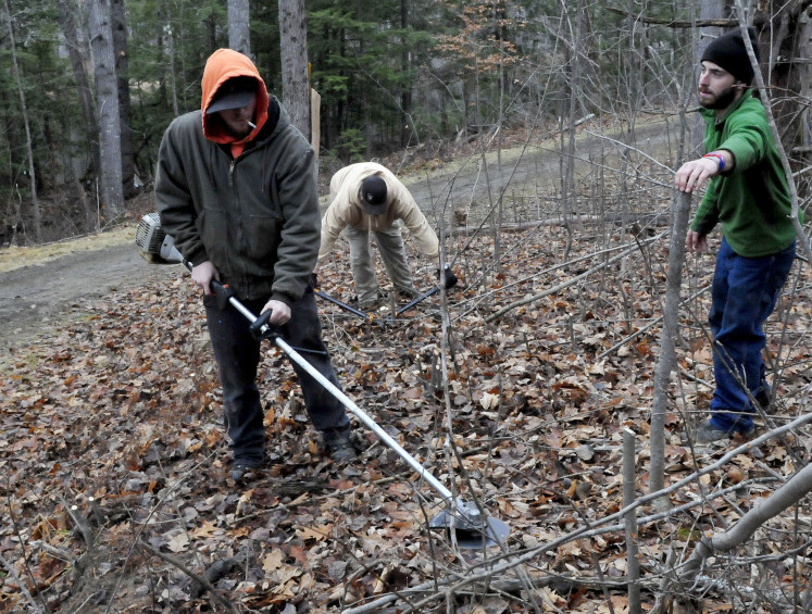 This year’s lack of snow has given Waterville Parks and Recreation workers a chance to do some trail maintenance along walking and skiing paths at the Quarry Road Recreation Area. Working Monday are, from left, Kail Demerchant, Chris Lill and Jack Flynn. The area opened Thursday and has some man-made snow to keep skiers happy.