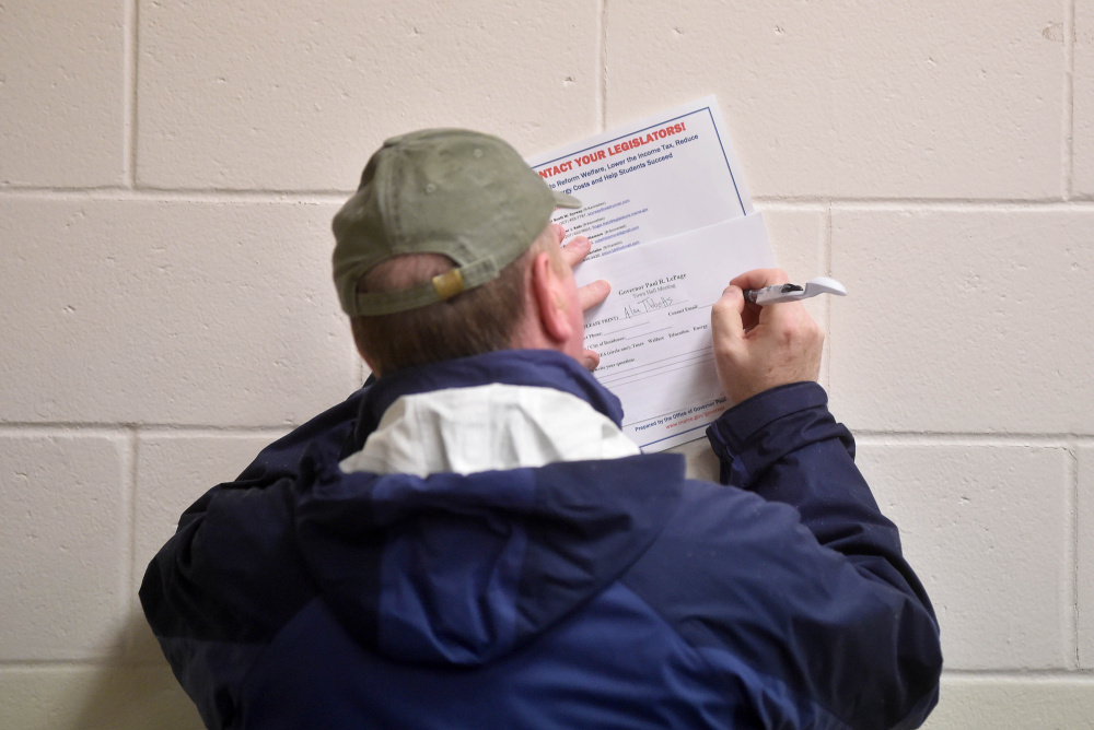 A member of the community fills out a question form for Gov. Paul LePage during a town hall meeting Thursday at Waterville Junior High School.