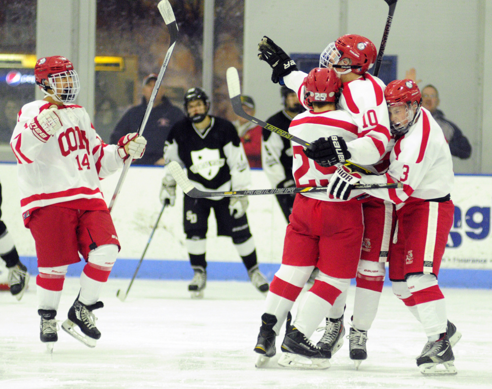 Cony’s Riley Boivin (10) is congratulated by teammates Avery Pomerleau (14), Logan Leadbetter (25) and Connor Perry after Boivin scored a second period goal  to take a 1-0 over St. Dominic on Thursday  at Camden National Bank Ice Vault in Hallowell.
