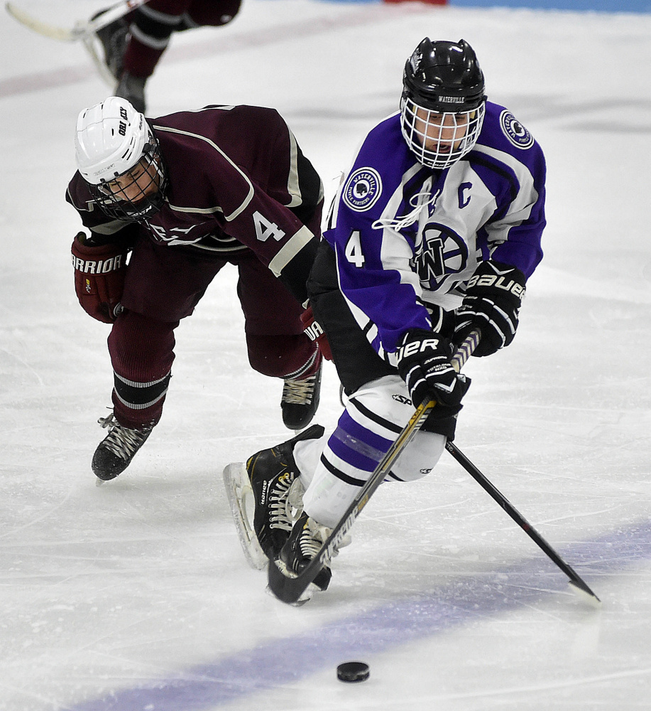 Waterville Senior High School’s Michael Oliveira (4) skates past Greely High School Colby Robinson (4) in the second period at Colby College on Thursday.