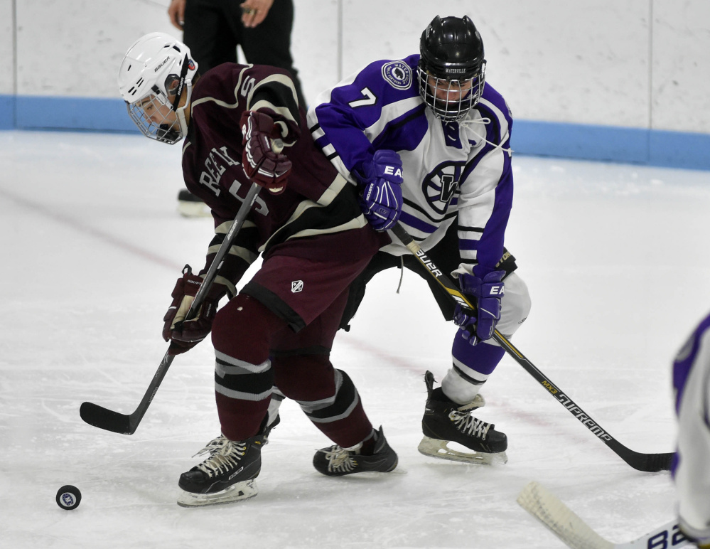 Greely High School’s Andrew Eckhardt (5) looks to clear the puck as Waterville Senior High School’s Nick Denis (7) tries to get the steal in the second period at Colby College on Thursday.