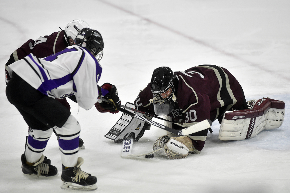 Greely High School goalie Joe McDonald (30) makes a save as Waterville Senior High School’s Michael Oliveira (4) looks for the rebound at Colby College on Thursday.