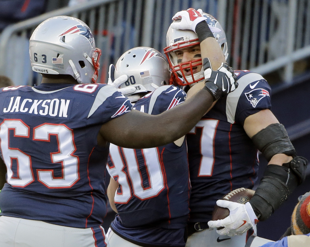 Patriots tight end Rob Gronkowski, right, celebrates his touchdown catch with guard Tre’ Jackson, 63, and wide receiver Danny Amendola in the first half Sunday against the Tennessee Titans in Foxborough, Massachusetts.