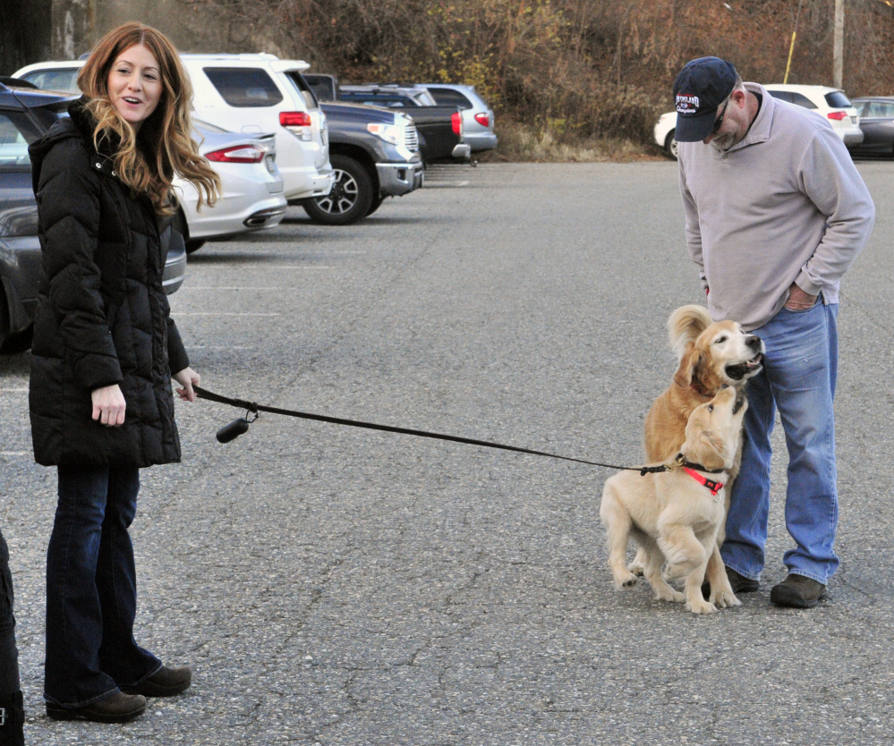 AmyLou Craig, left, and her puppy Brewer, stand with her father Lou Craig and his dog Miller on Nov. 24 in a parking lot near the Kennebec River Rail Trail in Augusta.