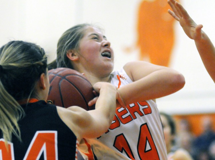 Gardiner Area High School’s Logan Granholm is blocked by Skowhegan Area High School’s Alyssa Everett, left, Tuesday in Gardiner.