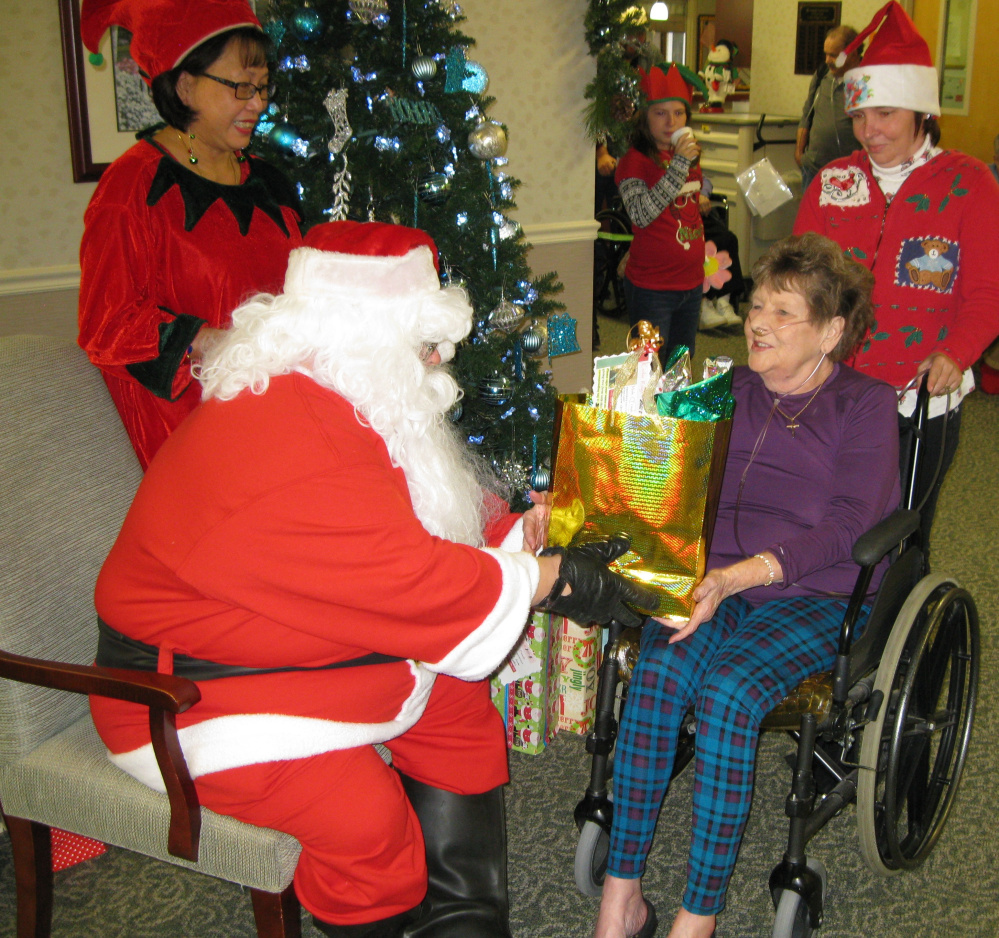 Contributed photos
Cedar Ridge resident Charlotte Spencer receives a gift from “Santa Claus,” John Grohs, Transportation and “Elf,” Activities Assistant Leni McCandless, and volunteer Theresa Drown
