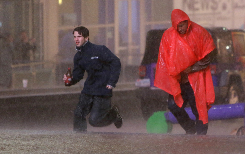People run as weather sirens sound as a severe storm passes over downtown Dallas, Saturday, Dec. 26, 2015, in Dallas. The National Weather Service said the Dallas area was under a tornado warning Saturday.