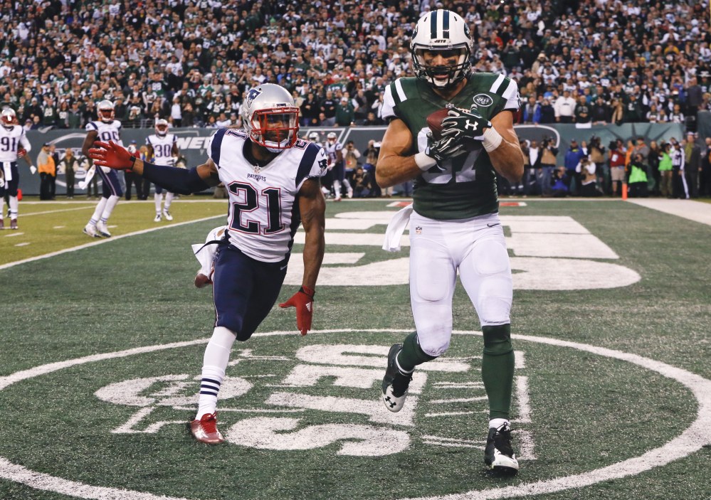 New York Jets wide receiver Eric Decker (87) catches a pass for a touchdown in front of New England Patriots’ Malcolm Butler (21) during the overtime period of Sunday’s game in East Rutherford, N.J. The Jets won 26-20.