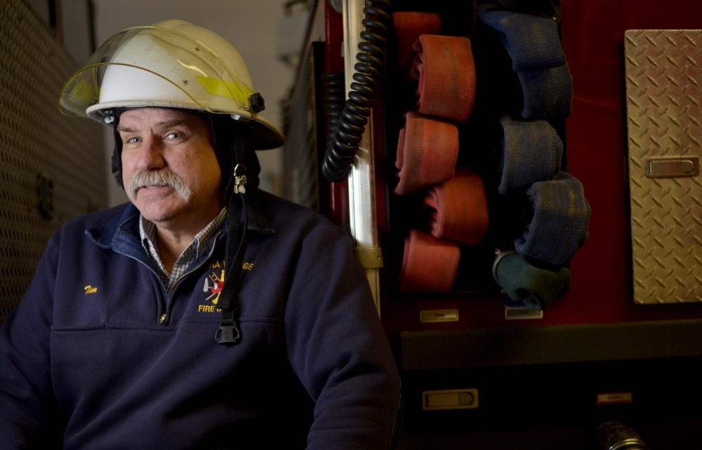 Tim Theriault, chief of the volunteer fire department in China Village sits by one of his trucks at the department in this February file photo. Theriault, who is also a state representiive, said he hopes that incentives under consideration by the Legislature will help shore up the state’s volunteer firefighting crews.
