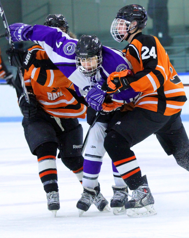 Waterville Senior High School’s Nick Denis (7) gets checked by Winslow High School’s David Selwood during first-period action at Colby College in Waterville on Monday. The teams played to a 4-4 overtime tie.