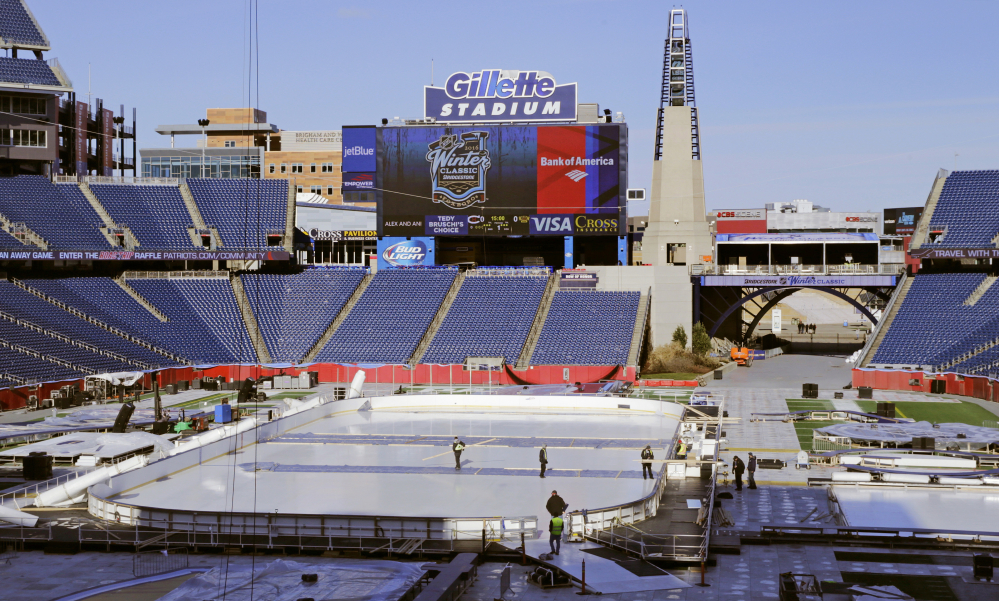 Workers prepare the Winter Classic hockey rink on the football field of Gillette Stadium in Foxborough, Mass. The Montreal Canadiens face the Boston Bruins in the New Year’s Day hockey game in the home of the New England Patriots.