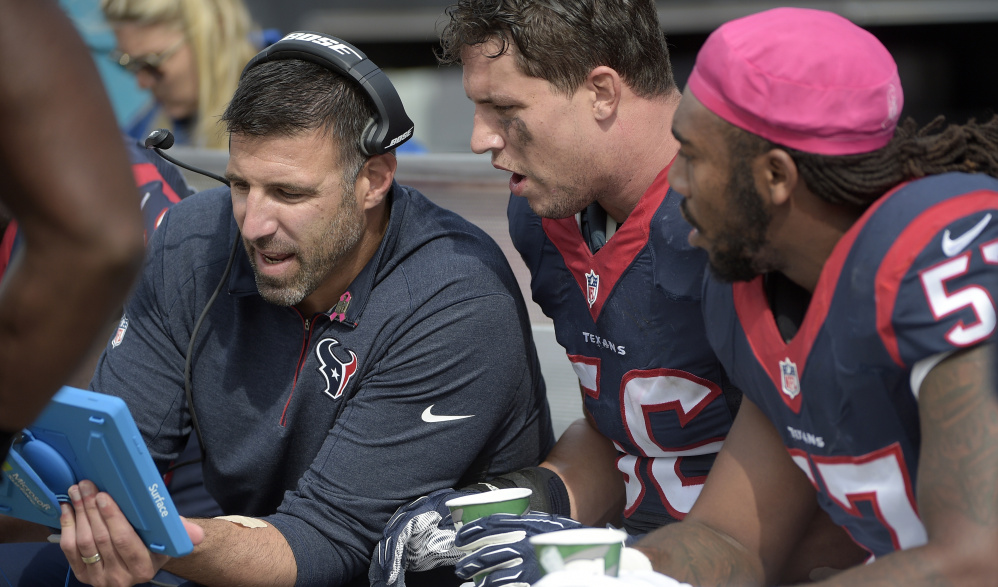 Mike Vrabel, left, linebackers coach for the Houston Texans, talks with Brian Cushing, center, and Justin Tuggle during a game on Oct. 18. Vrabel has long shown an interest in coaching, dating to his time as a linebacker with the Patriots.