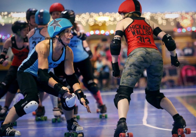 Kelley Hughes (skating name: Iris Kit) of the team R.I.P. Tides prepares to make contact with Marnie Williamson (Chickadee Wallop) of the Calamity Janes during a bout Saturday at Happy Wheels in Portland. 