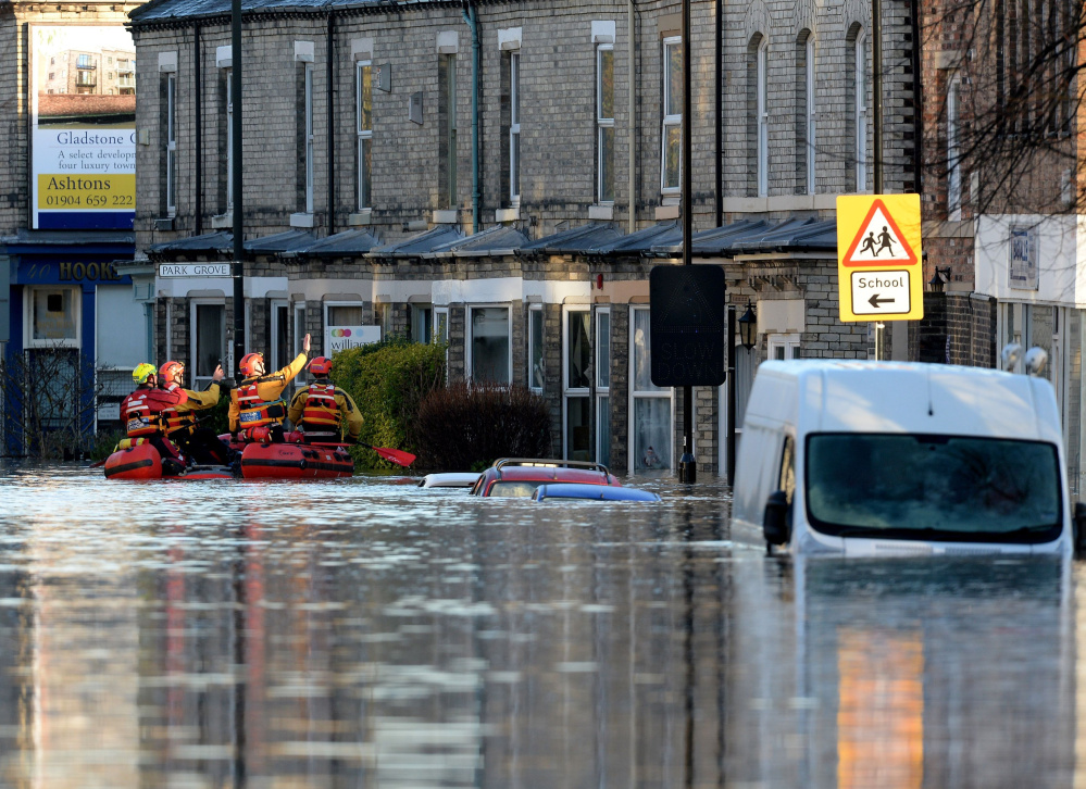 Members of a mountain rescue team check on properties after the rivers Foss and Ouse burst their banks, in York, England, on Sunday. Hundreds were forced to evacuate.