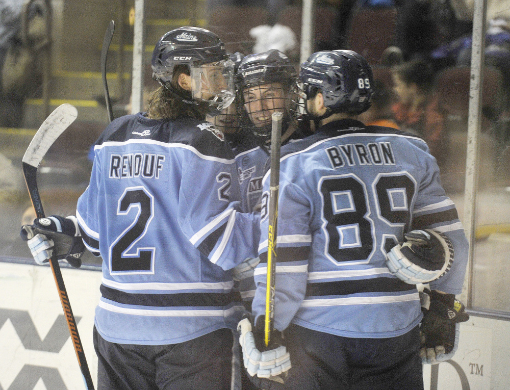 PORTLAND, ME - DECEMBER 28: The University of Maine hockey team played the University of New Hampshire at the Cross Insurance Center on Tuesday night. UMO's#3, Rob Michel, is congratulated by teammates Dan Renouf and Blaine Byron following his goal in the second period. (Photo by John Ewing/Staff Photographer)