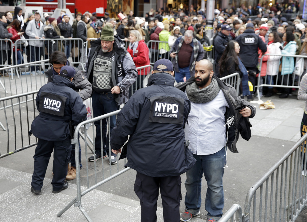 Pedestrians wait to be searched as they enter Times Square in New York on Thursday. About 1 million people are expected to attend festivities on Times Square, along with nearly 6,000 New York City police officers, including members of a specialized counterterrorism unit.