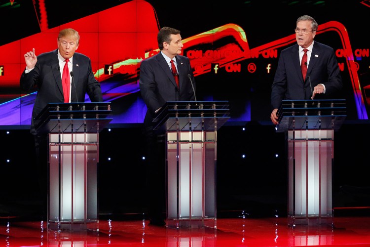 Donald Trump, left, and Jeb Bush, right, speak as Ted Cruz looks on during Tuesday night's Republican presidential debate in Las Vegas. Bush, needing a strong debate performance, was aggressive in seeking to discredit Trump.
The Associated Press
